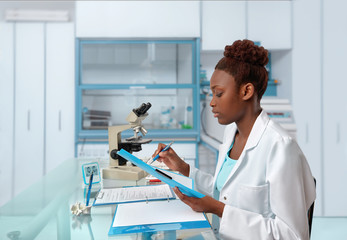 African-american biologist checks records in scientific lab or research facility - obrazy, fototapety, plakaty