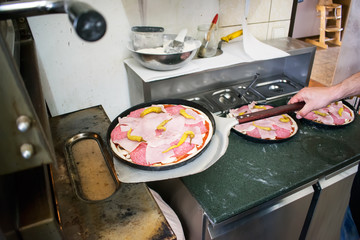 Close up cooking italian pizza in small restaurant