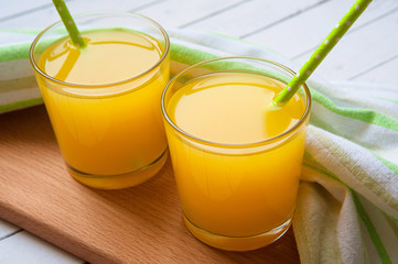 Glass full of orange juice and fresh sliced orange on old wooden table
