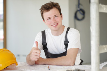 Handwerker positiv lächelnd auf einer Baustelle 