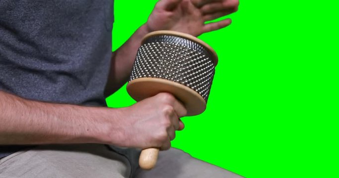 Mid section of male musician playing cabasa