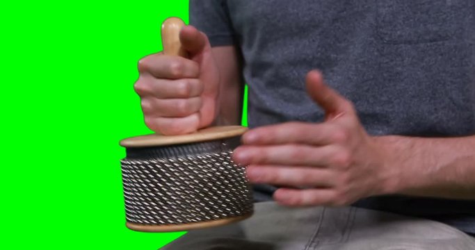 Mid section of male musician playing cabasa