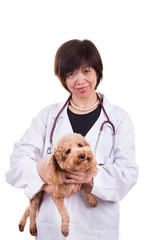 Smiling Asian female veterinary doctor hugging pet dog