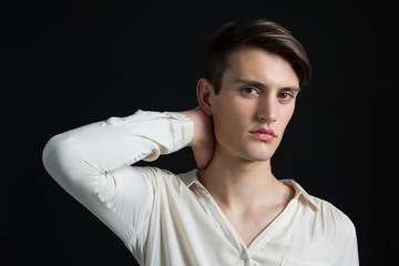 Androgynous man posing with hand on his neck