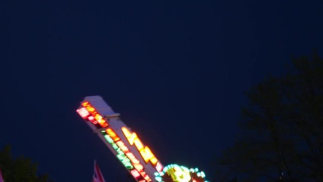 Spinning Fun Fair / Carnival Ride, Light up Against Night Sky