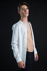 Androgynous man posing in open buttondown shirt