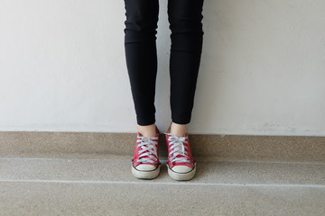 Feet From Above Concept, Teenage Person in Red Sneakers Standing on Ground Background Great for Any Use.