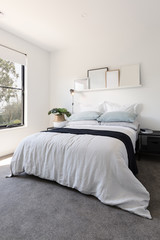 Fototapeta na wymiar Gorgeous bedroom with luxury linen and a pot plant