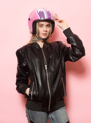 Biker girl wearing black leather jacket and pink motorcycle helmet.