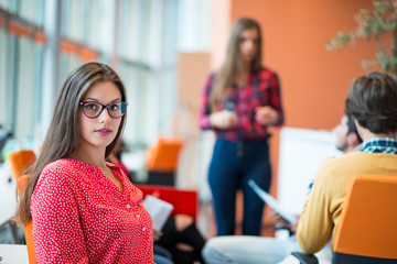 happy young business woman with her staff, people group in background at modern bright office indoors