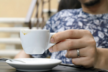 Fototapeta na wymiar Man holding small coffee espresso empty cup