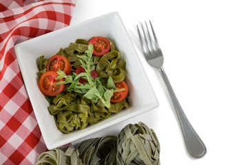 Close up of pasta in bowl by napkin