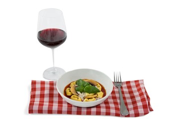 Close up of cooked tortelloni on napkin by wineglass