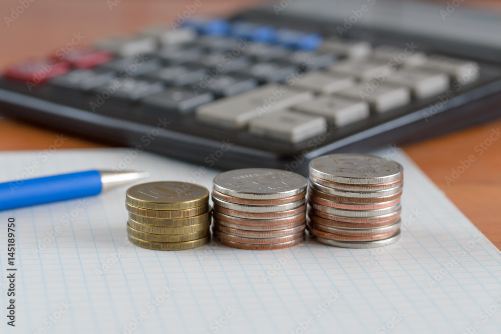 Wall mural coins and calculator on the table surface.