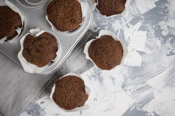 Chocolate muffins on the rustic background. Selective focus.