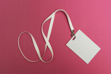 Blank Security Tag with White Neck Band Isolated on Pink Background.