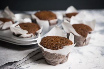 Chocolate muffins on the rustic background. Selective focus.