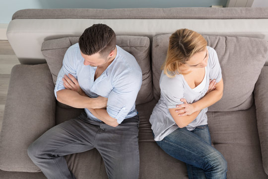 Upset Couple Sitting On Couch