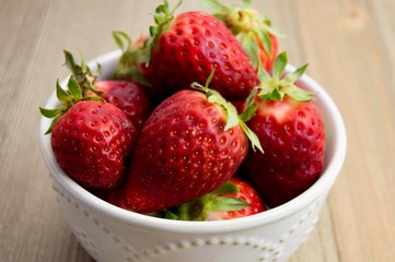 Fresh strawberries in a decorative white bowl