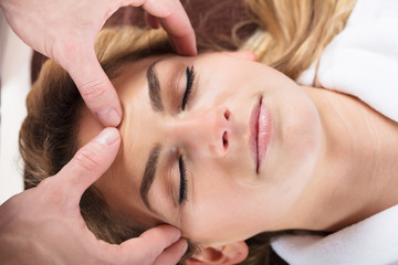 Therapist Giving Massage On Woman's Forehead