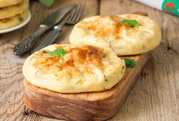 Potato herbs and cottage cheese small flat breads served on a wooden board. Copy space and vertical view.