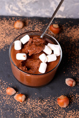 Chocolate mousse with marshmallows in portion glasses on slate cheese board