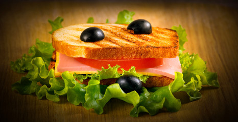 Sandwich with olives, cheese, tomato and bacon