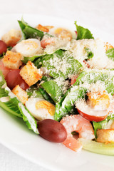 salad of romaine lettuce with prawns, quail eggs, croutons, cherry tomatoes, and kalamata olives with caesar dressing and grated parmesan