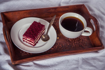 Breakfast in bed. Cup of coffee and red velvet cake
