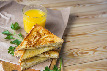 Cheese toasts for breakfast and orange juice in glass. Sandwich for a breakfast