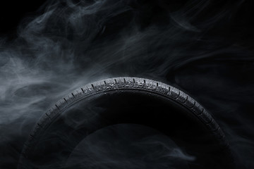 Car tire covered with water drops in the fog