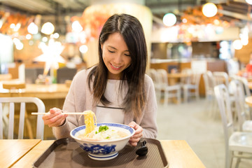 Woman enjoy her japanese noodles in restaurant