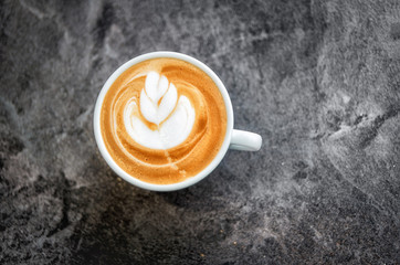 White cup with fresh cappuccino with a beautiful pattern on the foam