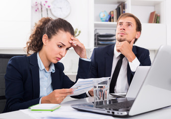 Fototapeta na wymiar sad man and sorrowful woman coworkers in firm office