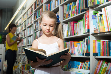 Girl in school age taking open chosen book