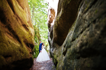 Fototapeta na wymiar Lovely wedding couple at amazing landscapes with rock Dovbush, Carpathian mountains at Ukraine.