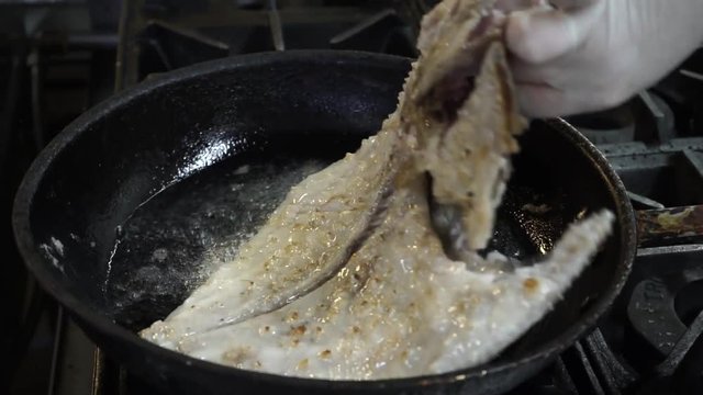 seafood. Fried fish in a frying pan - flounder. Overturning of fish