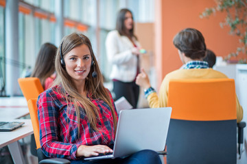 happy young business woman with her staff, people group in background at modern bright office indoors