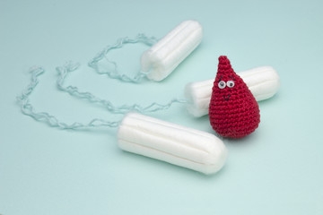 Three menstruation sanitary soft cotton tampon for woman hygiene protection and crochet funny blood drop. Woman critical days, gynecological menstruation cycle. Medical conception photo