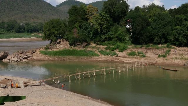Monks building bamboo bridge across the River in Luang Prabang Laos
