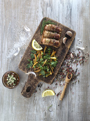 Fried sausages with bacon on a wooden board. 