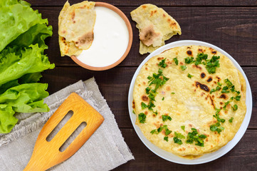 Thin flatbread - traditional Asian bread on a dark wooden background. The top view