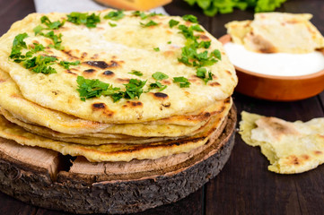 Thin flatbread - traditional Asian bread on a dark wooden background.