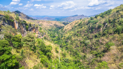 Fototapeta na wymiar aerial photography above amazing cave. Tham Than Lod Yai is the big cave and have one hole on the top of the cave. it is a short cave there have waterfall pass inside through to another cave 