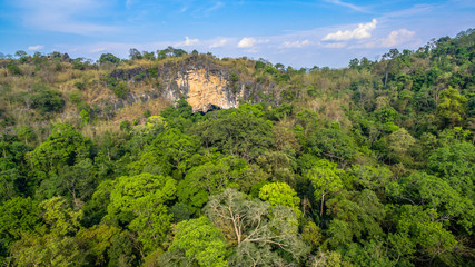 Fototapeta na wymiar aerial photography above amazing cave. Tham Than Lod Yai is the big cave and have one hole on the top of the cave. it is a short cave there have waterfall pass inside through to another cave