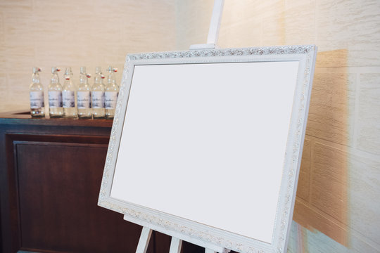 White frame stands on the easel before the bar