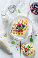 Fototapeta na wymiar Homemade sweet waffles with berry fruits and whipped cream