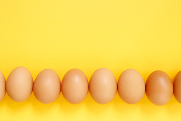 Fresh eggs on yellow background