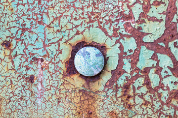 Old obsolete rusty metal surface with round rivet in the middle and cracked decay green paint as vintage, corroded, peeling background