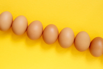 Fresh eggs on yellow background